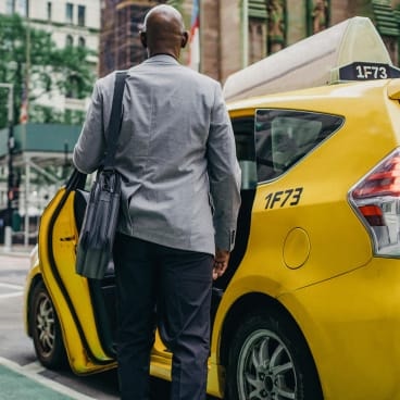 Businessman getting into a yellow New York City taxi